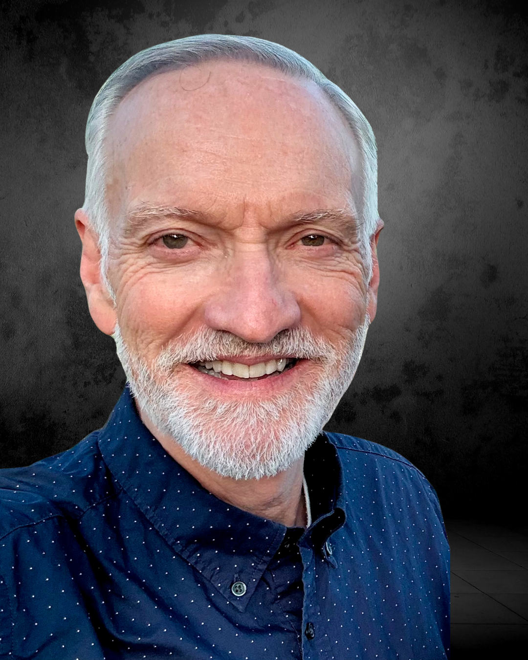 Portrait of Paul Mullins, a grey-haired white man with short white facial hair.