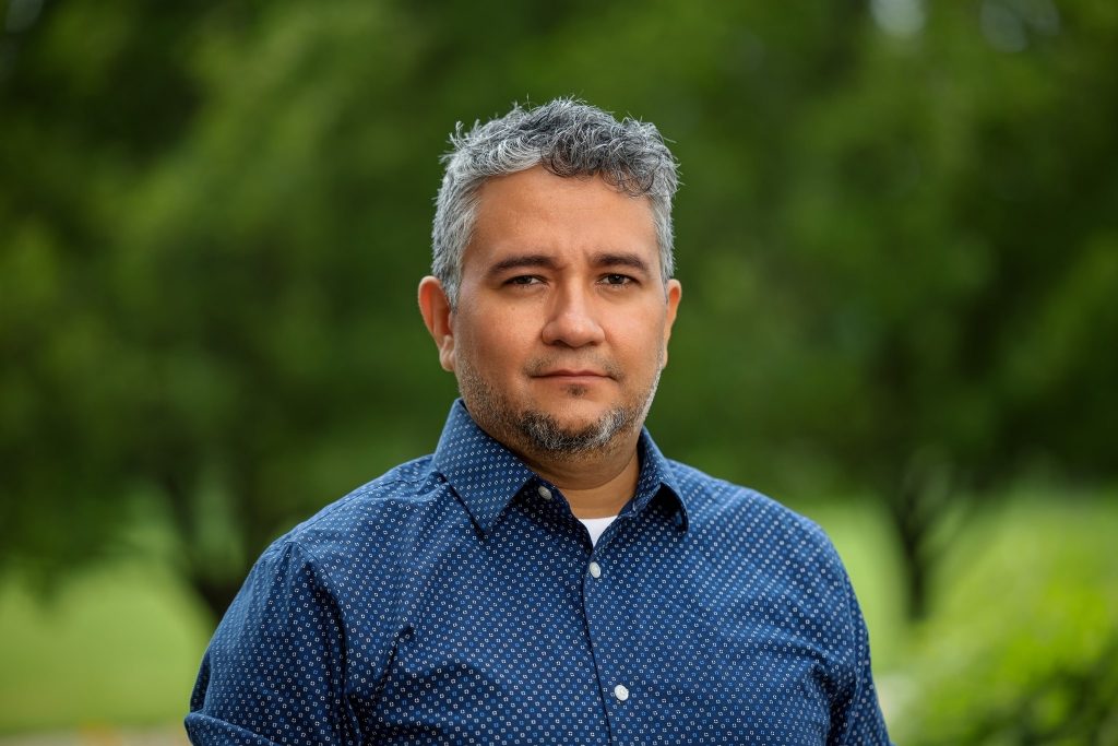 Portrait of director Tlaloc Rivas, a Latinx man with greying hair and a short beard.