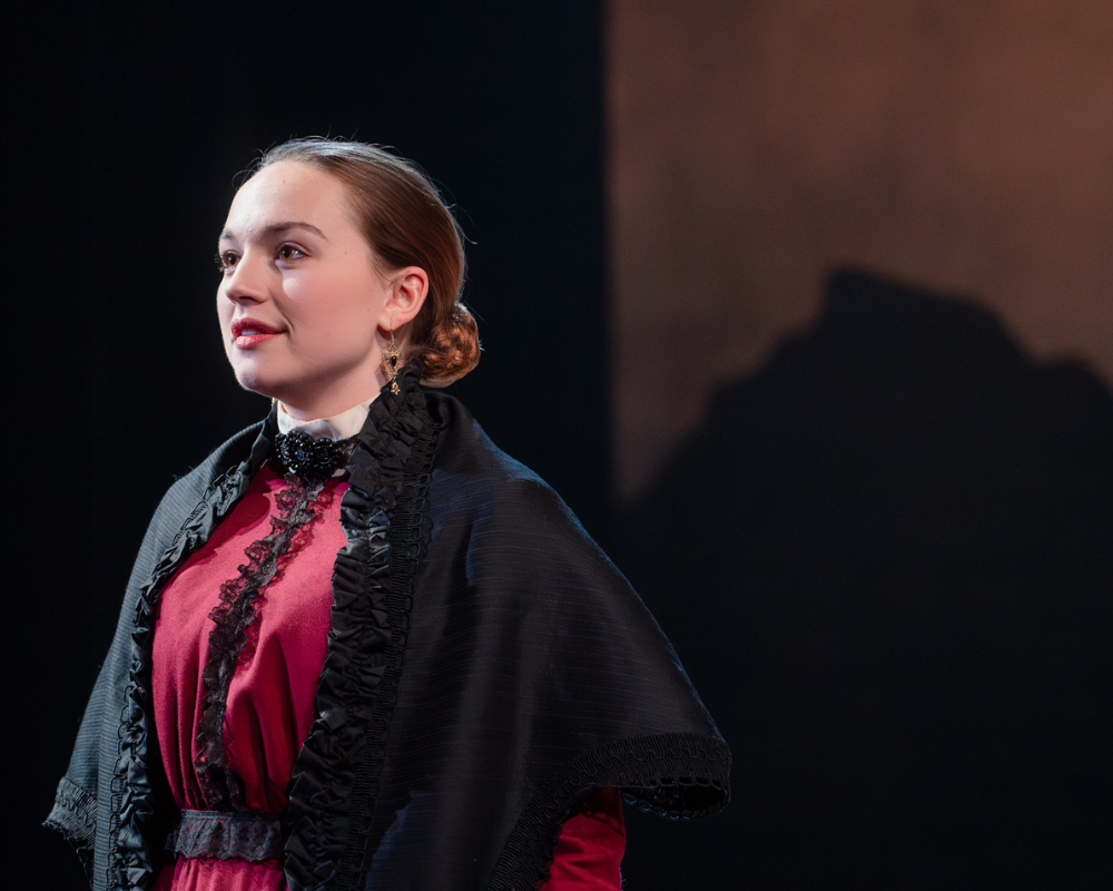 The the 2024 production of The Moors, Agatha (played by Kat Corrigan) wistfully stares out toward the audience as she contemplates a different life.
