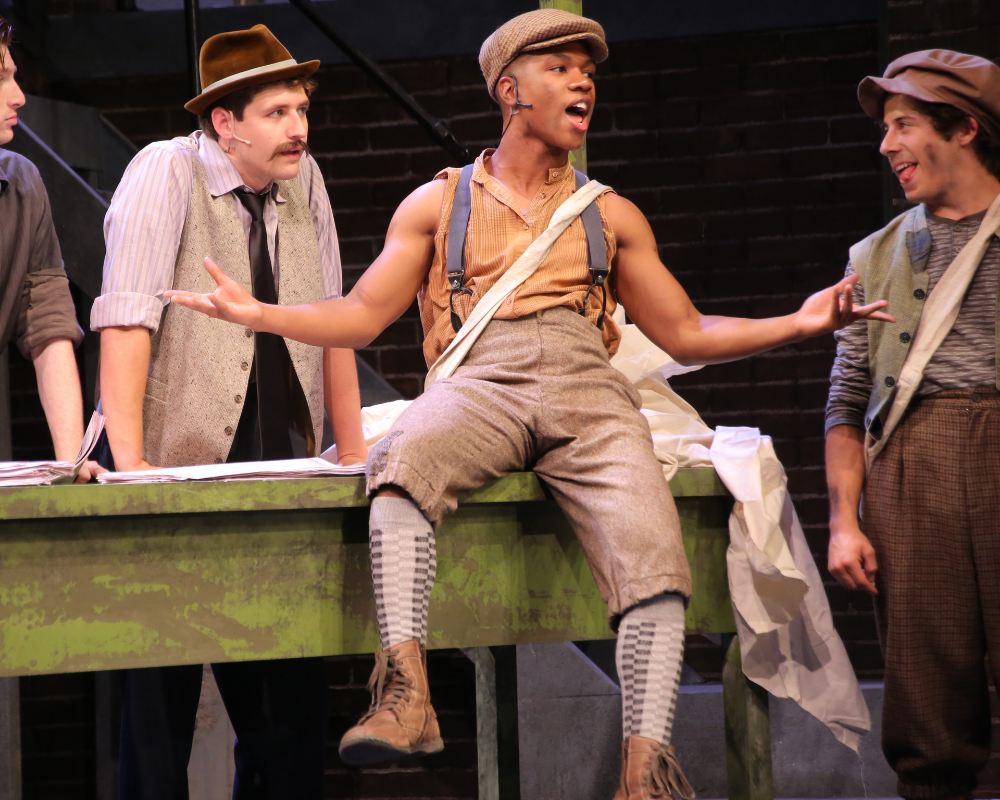 Young men from Newsies, dressed in bedraggled clothing.